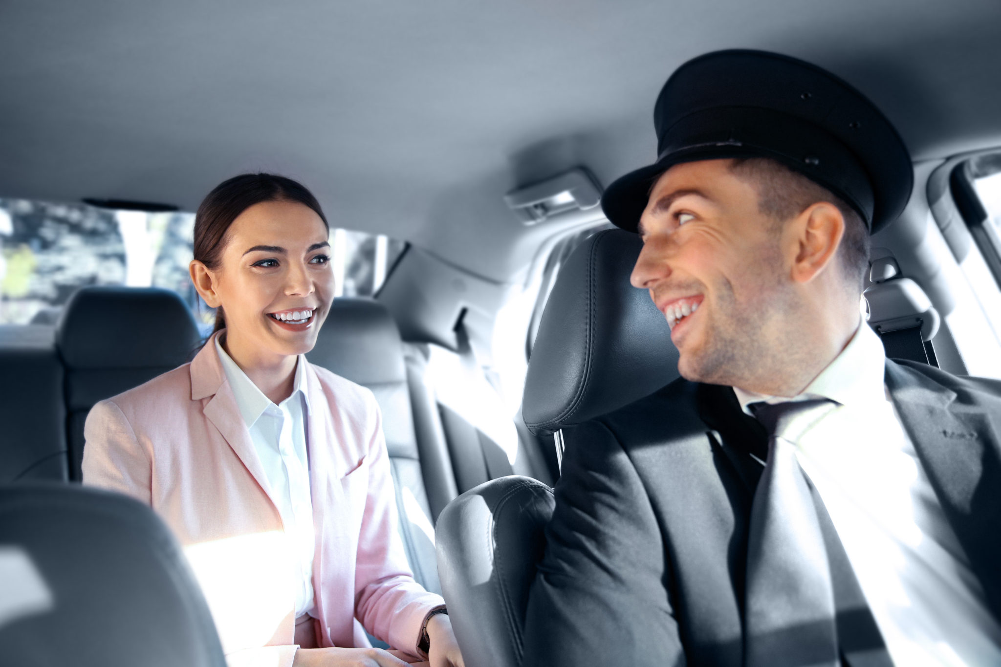 Businesswoman riding a car with chauffeur